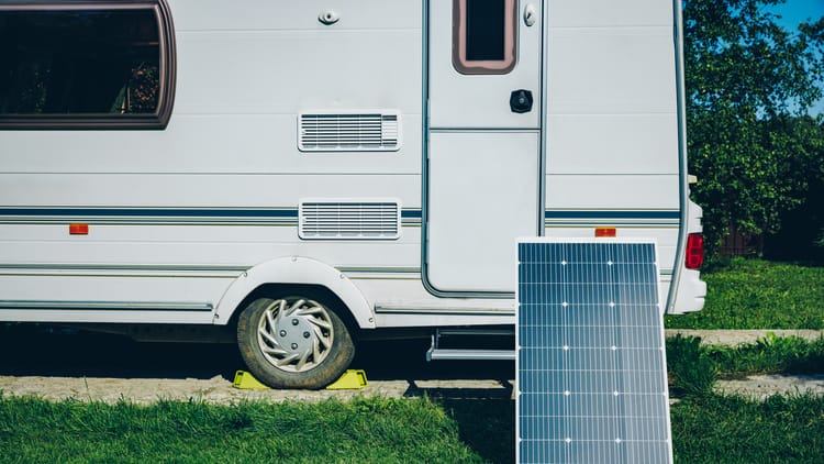 white-rv-caravan-camper-on-a-campsite-with-solar-panel